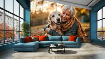 mature woman hugging her dog outside in her yard Wall mural