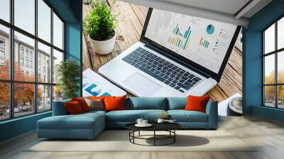 Photo laptop is displayed on a wooden table, showcasing charts and graphs related to analysis, business accounting, and statistics concepts. Wall mural