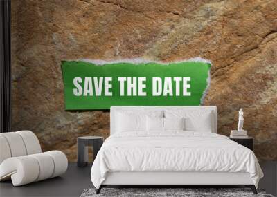 Save the date message written on ripped torn green paper piece with stone background. Conceptual save the date symbol. Copy space. Wall mural