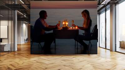 A young couple share a romantic dinner with candles on the beach Wall mural