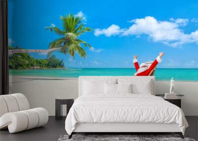 Christmas Santa Claus on deckchair enjoing palm sady ocean beach Wall mural