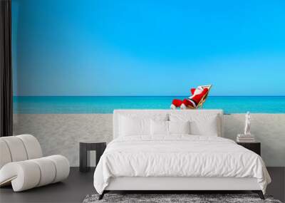 christmas santa claus resting on sunlounger at ocean sandy tropical beach Wall mural