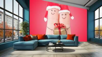 fingers faces in santa hats with gift box. happy couple concept Wall mural