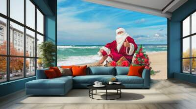 Santa Claus at sea beach with many gifts and decorated christmas Wall mural