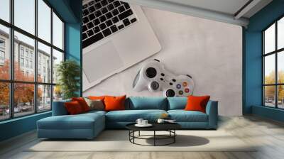 Wireless PC game controller on a grey background. Game console with a laptop. The concept of video games. Leisure at home during an outbreak of the coronavirus. Horizontal orientation. Copy space Wall mural