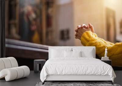 Christian woman is praying with hands crossed in church  Wall mural