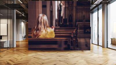 Young woman praying and meditating in church Wall mural