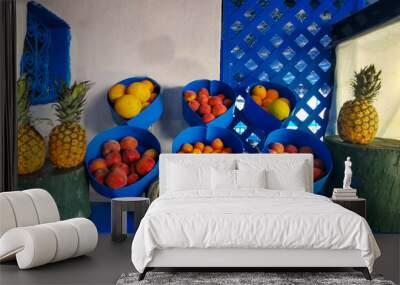 Various exotic fruits are displayed on a blue background. Wall mural