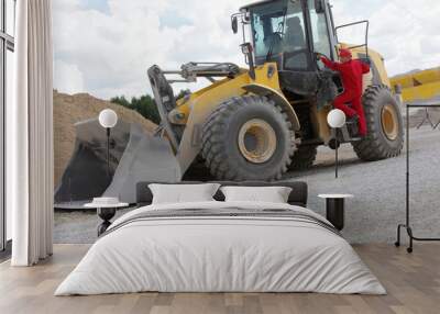 Driver opening cab door to  bulldozer  on construction site Wall mural