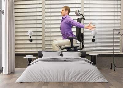 man exercising on chair in office, healthy lifestyle - profile view Wall mural