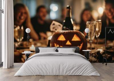 Halloween party, pumpkin and champagne bottle on a table with a group of friends having fun in the background Wall mural