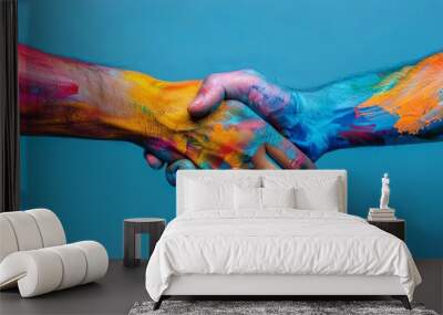 two hands shaking, painted in different colors on blue background Wall mural