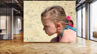 Little girl  on the background  of a sandy beach Wall mural