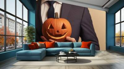 Businessman in a suit holds a funny jack-o-lantern, perfect for halloween parties. The festive image has a playful vibe with orange and black colors Wall mural