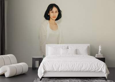 Young cute teen girl in jeans and shirt on a white background Wall mural