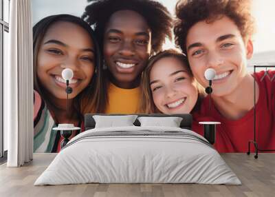 Four diverse Gen Z friends taking outdoor group selfie at the beach wearing bright colors. Summer fun, beach party, student travel, road trip, diversity. Square, social media. Group portrait. Wall mural