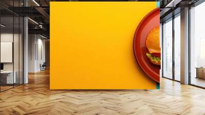 Delicious burger on vibrant plate, featuring fresh lettuce, tomato, and cheese, set against bright yellow and turquoise background Wall mural