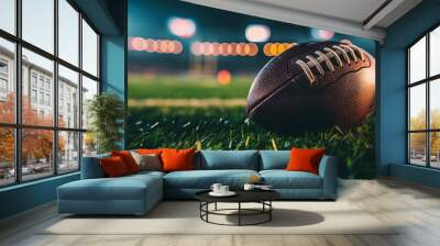 closeup of an American football ball on the grass of a stadium at night about to start a game Wall mural