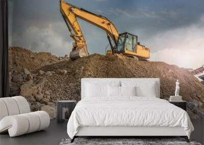 A large yellow excavator moving stone in a quarry Wall mural