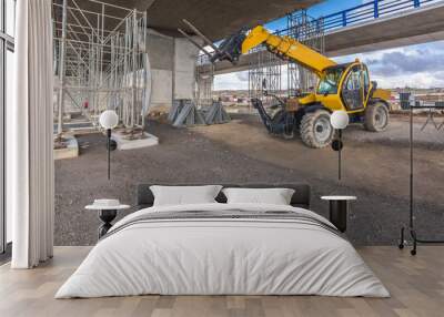 Telehandler on a construction site, preparing to raise construction parts Wall mural