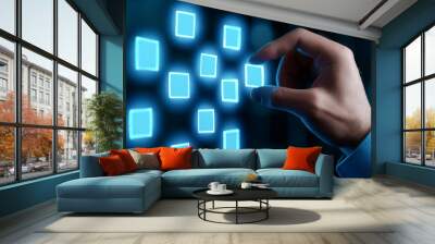 A hand interacts with a digital screen displaying glowing square icons, symbolizing technology and innovation. Wall mural