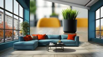 A modern indoor scene featuring a vibrant green plant in a sleek black pot on a wooden table, enhancing the cozy atmosphere. Wall mural