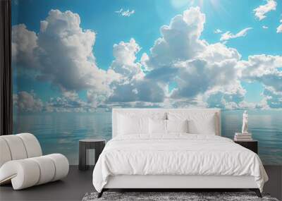 A serene view of a calm ocean with fluffy white clouds and a bright blue sky, perfect for relaxation and travel concepts. Wall mural