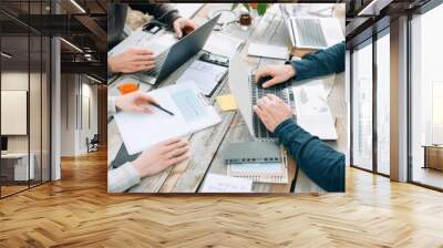 Close-up of colleagues working with their laptops together at the same table. Cowerking concept Wall mural