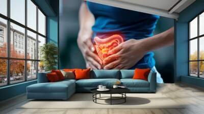 Woman holds with both hands the area of the gut illuminated in 3D with the intestine Wall mural