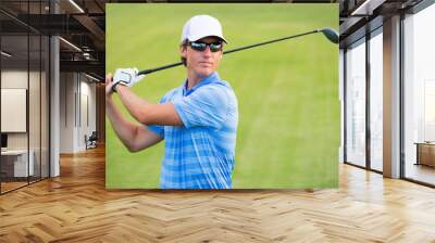 Athletic young man playing golf Wall mural