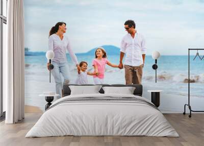 Happy young family walking on the beach Wall mural