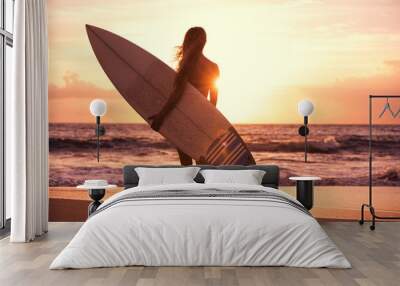 Silhouette surfer girl on the beach at sunset Wall mural