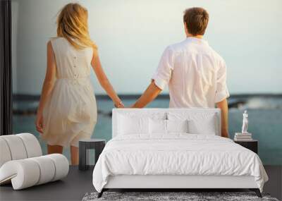 Young couple in love on the beach sunset Wall mural