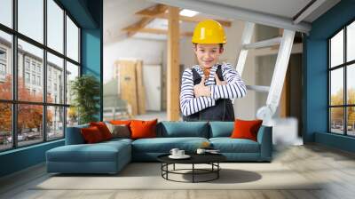 cool young boy with yellow safety helmet posing and having fun on construction building site indoor in a loft Wall mural