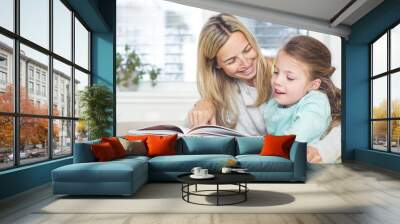 Mother is reading a book with the child Wall mural