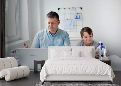 Stay at home, work from home concept during coronavirus pandemic. Father with kid working from home during quarantine. Wall mural