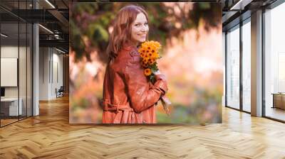 Woman in ginger leather coat, flowers, happy Wall mural