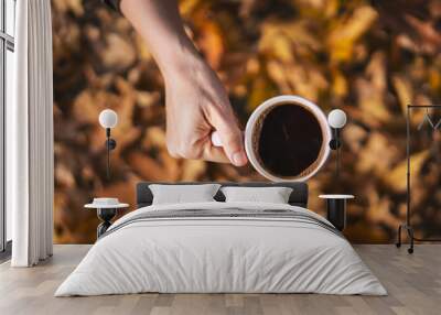 Autumn leafs and coffee cup on wooden table. Wall mural