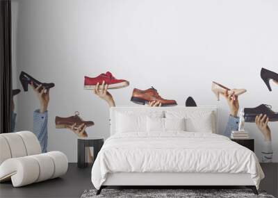 Hands holding different shoes on isolated background Wall mural