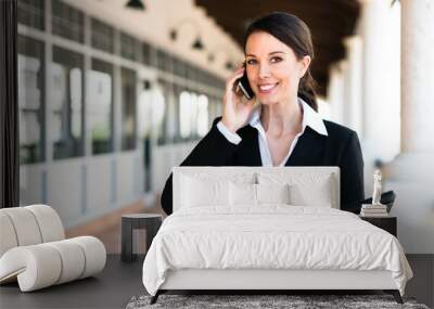 attractive businesswoman executive real estate agent broker talking on phone outside office space Wall mural