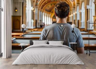 teenage male model from behind wearing trendy grey tshirt inside a church Wall mural