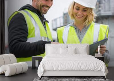 Woman in protective workwear and construction worker in construction site Wall mural