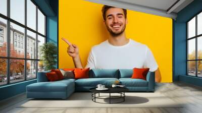 handsome man in white t-shirt pointing with fingers at himself isolated on yellow Wall mural