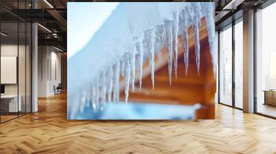 Hanging frozen icicles on the roof of a home or a house create a beautiful yet dangerous winter Wall mural