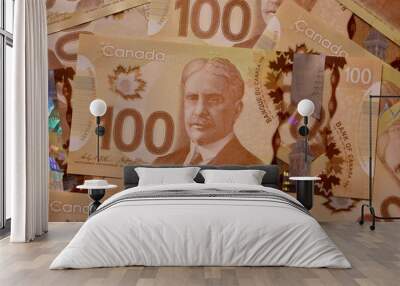 Canadian hundred dollar bills are scattered on a surface.  Wall mural