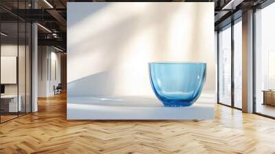 Empty blue glass cup on white wall background Wall mural