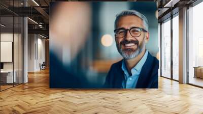 A man wearing glasses is smiling and looking at the camera Wall mural