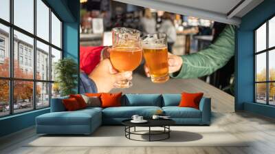 Friends celebrating with beers in a pub Wall mural