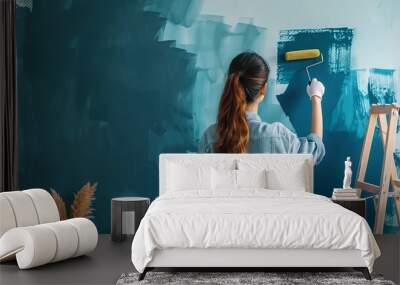 Woman painting over the plain tone tapestry of her living room, using a roller to paint Wall mural