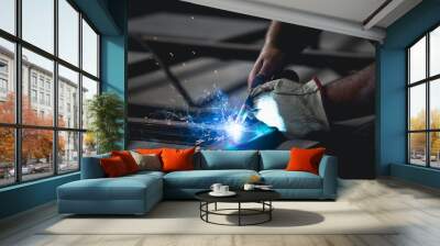 Industry worker welding iron pieces at work Wall mural